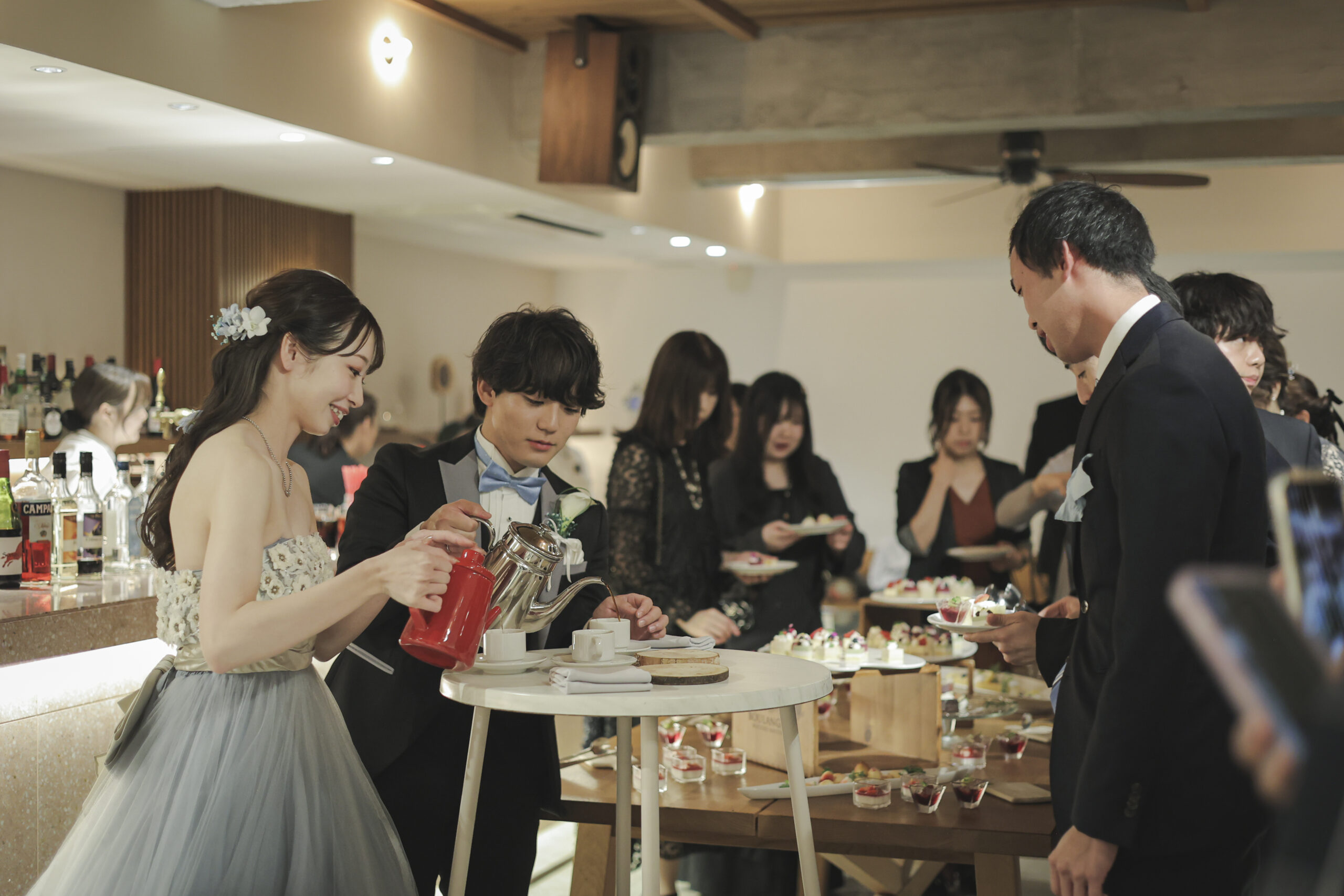 バーカウンターでゲストをもてなす新郎新婦 TOASTの1.5次会の歓談シーン 神戸北野